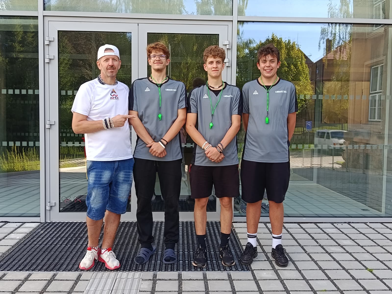 Noví rozhodčí Apex Sports Academy s trenérem před halou